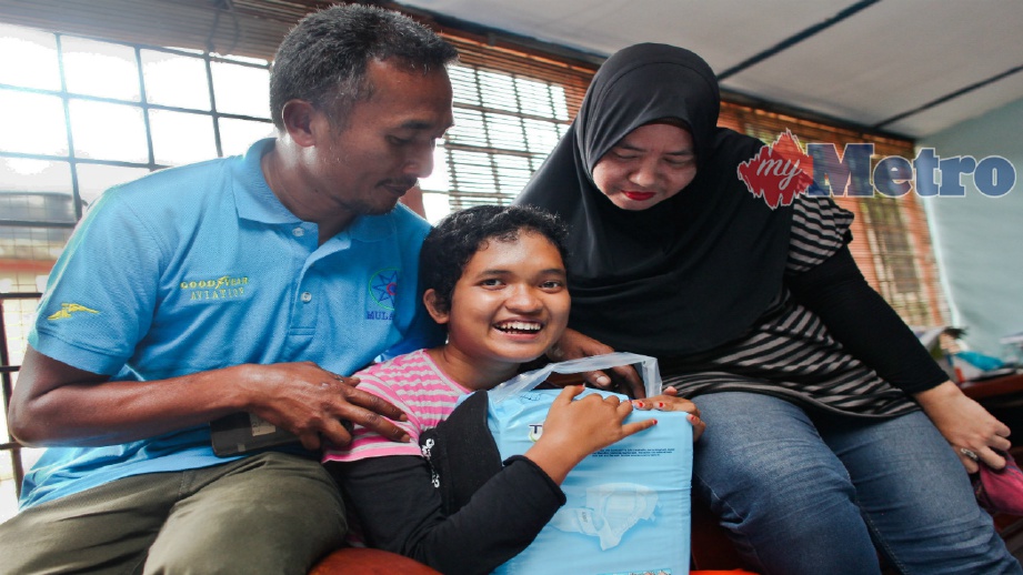 EMANINA (tengah) bersama Maizura dan Mohd Zain selepas menerima bantuan di rumah keluarganya di Seremban, hari ini. FOTO Adzlan Sidek