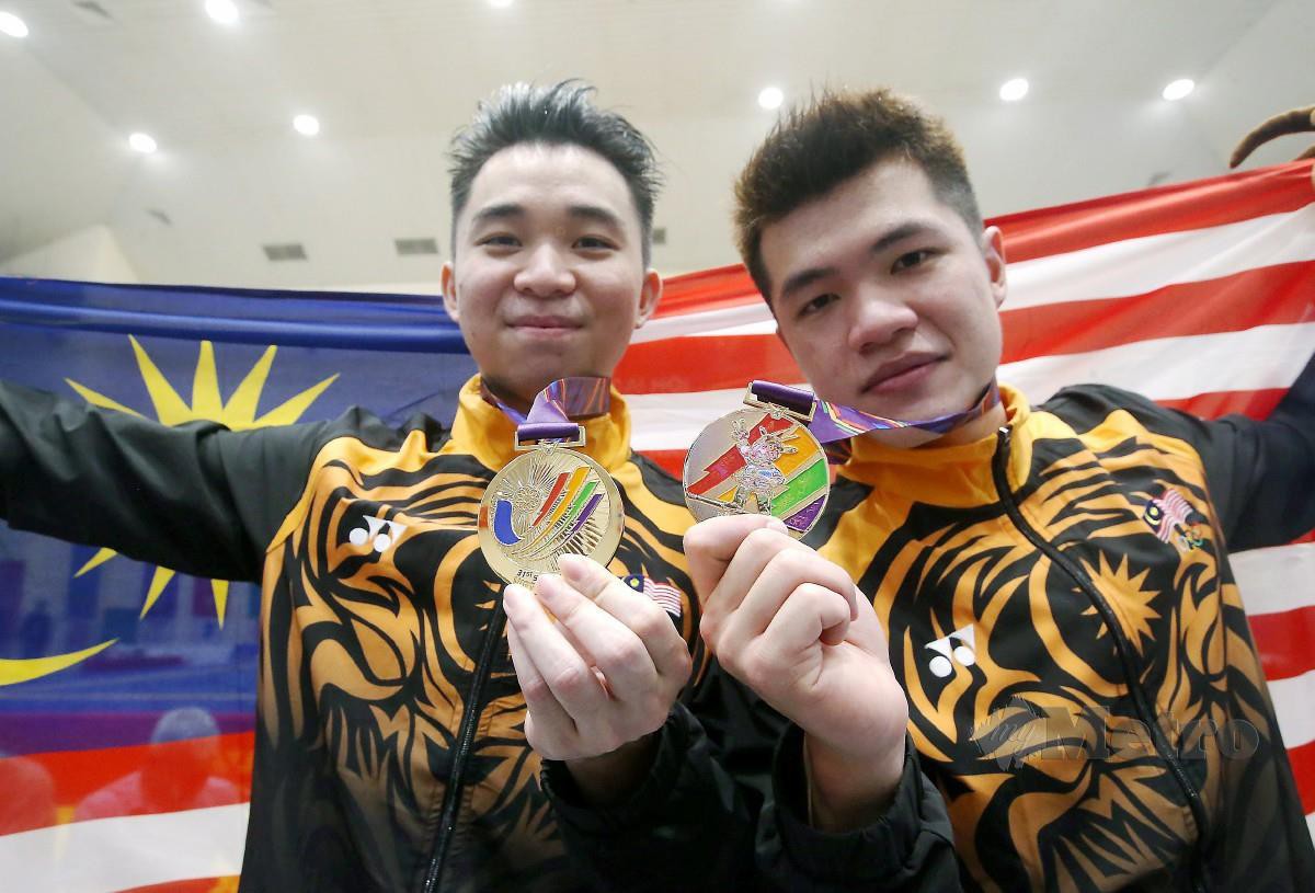 ZHI Yan (kiri) dan Clement Ting bersama pingat emas mereka. FOTO Eizairi Shamsudin