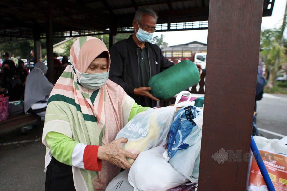 DAYANG Salbiah bersama Mohamad Ariff  menyiapkan barang keperluan untuk menyertai misi bantuan pasca  banjir di Pahang. FOTO GHAZALI KORI