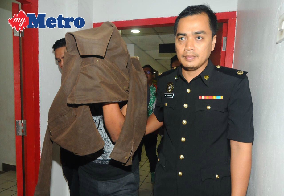 Syed Ahmad diiringi keluar di Mahkamah Sesyen Kuala Terengganu.