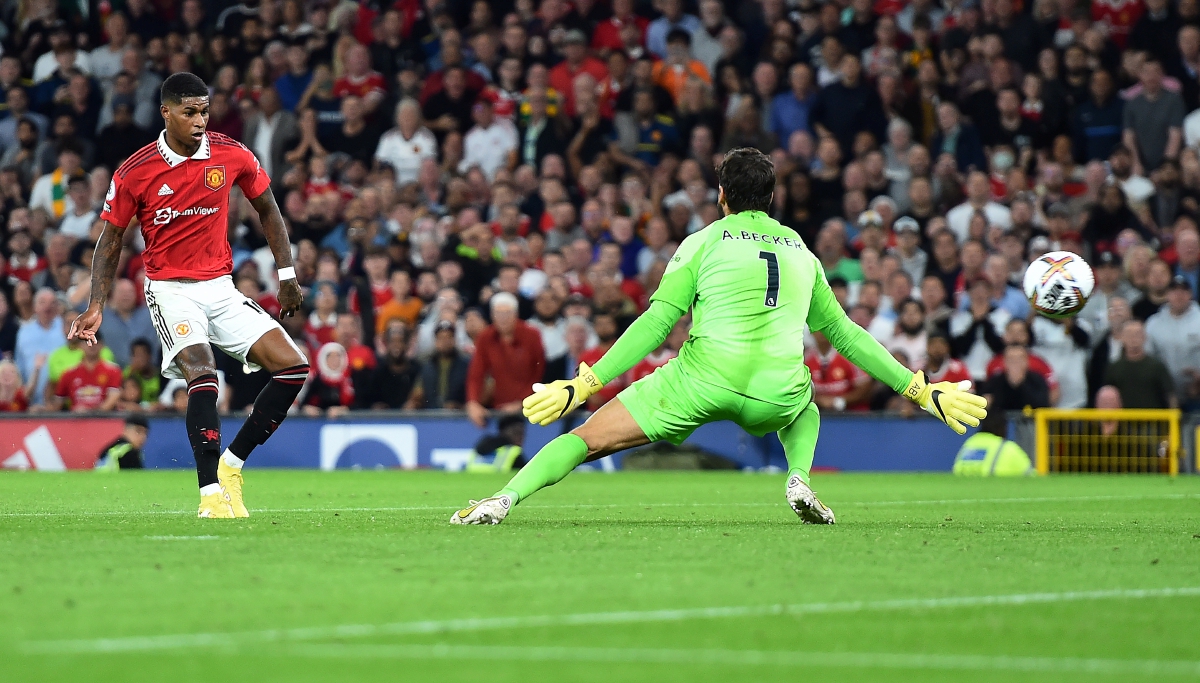 PENYERANG Manchester United, Marcus Rashford (kiri) mengatasi penjaga gol Liverpool, Allison untuk gol kedua pasukannya. FOTO EPA 