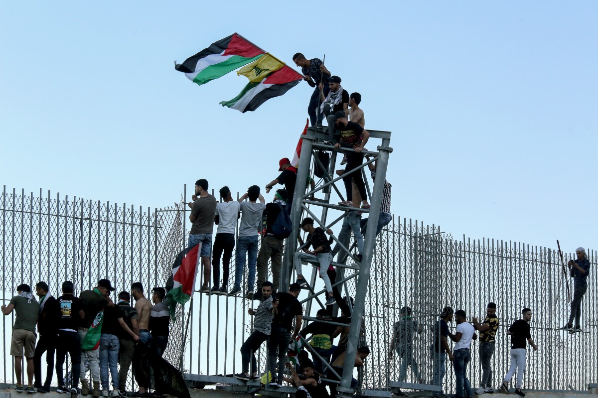 FOTO fail pada 15 Mei menunjukkan sekumpulan penunjuk perasaan dari Lubnan memanjat pagar sempadan dengan Israel. FOTO EPA 