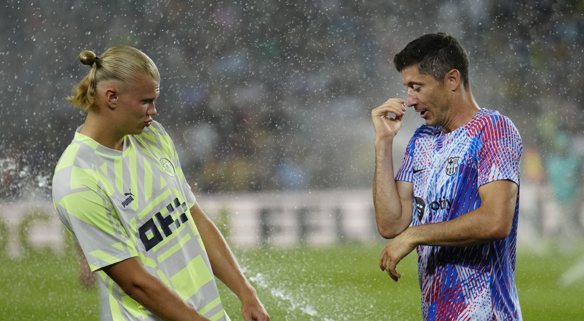 PENYERANG Barcelona, Robert Lewandowski (kanan) bergurau dengan penyerang Manchester City, Erling Haaland ketika perlawanan persahabatan di Camp Nou, Rabu lalu. FOTO EPA 