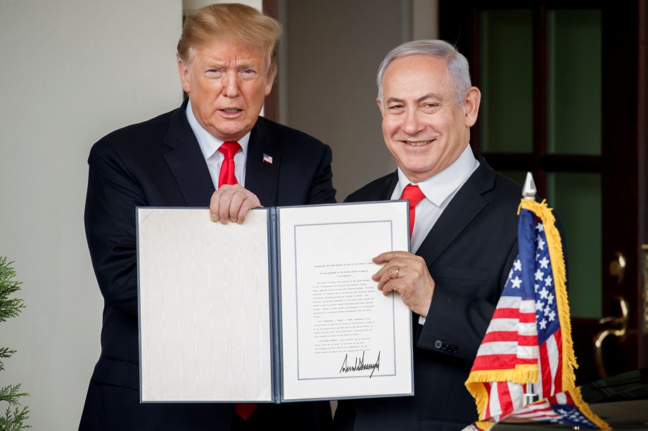 TRUMP (kiri) dan Netanyahu menunjukkan deklarasi mengiktiraf kedaulatan rejim Israel ke atas Bukit Golan.  FOTO AFP