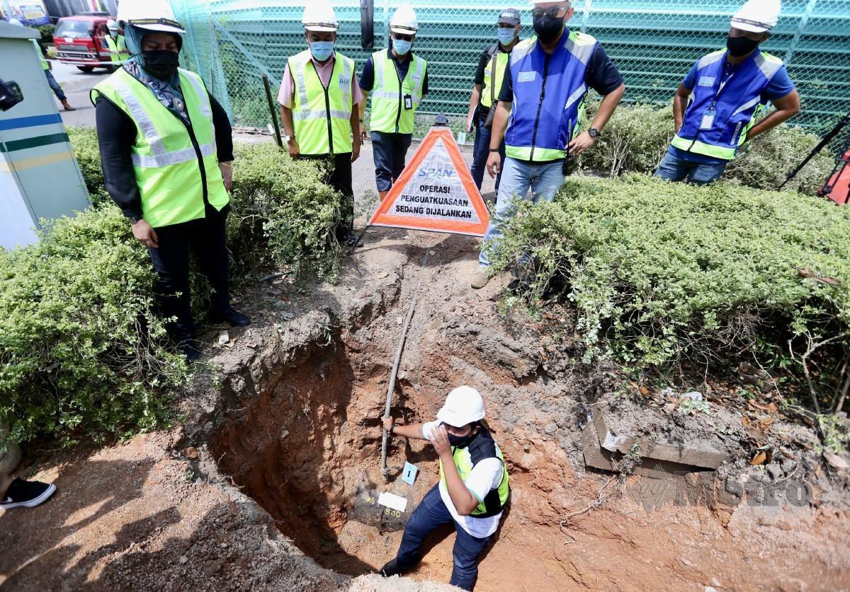 MOHD Fazil menunjukkan paip yang disambung secara tidak sah daripada paip utama milik Air Selangor di sebuah tapak pembinaan di Desa Parkcity. FOTO FATHIL ASRI
