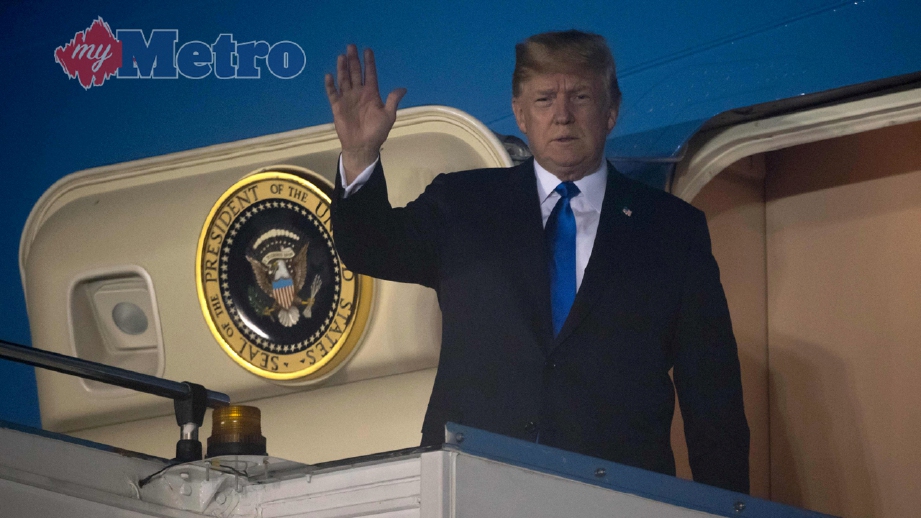 Trump melambai selepas Air Force One mendarat di Lapangan Udara Paya Lebar di Singapura. FOTO AFP 