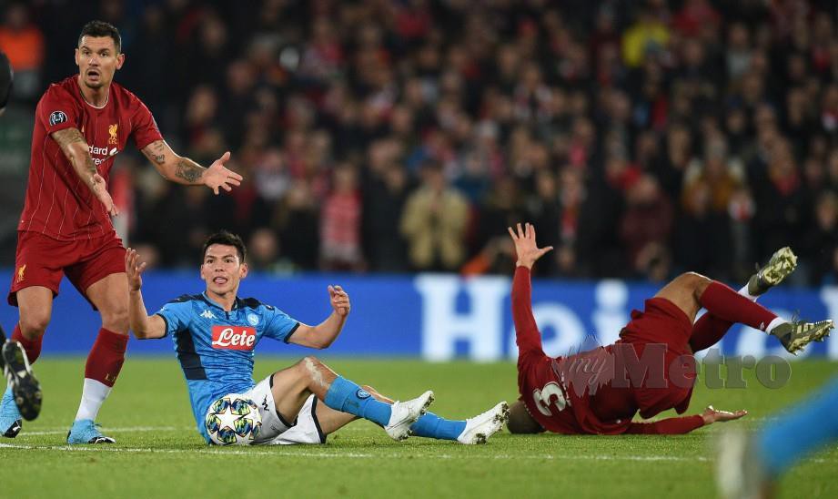 FABINHO (kanan) cedera selepas bertembung dengan pemain Napoli, Hirving Lozano (tengah) di Anfield. — FOTO AFP
