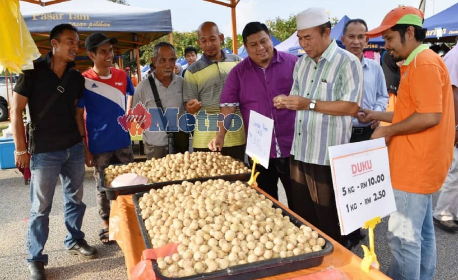 WAN Hapandi (dua kiri) bersama Halmi (tiga dari kiri) meninjau buah-buahan dijual selepas merasmikan Pasar Tani ke-31 di Terengganu di Sura Jeti, Dungun, semalam. FOTO Rosli Ilham. 