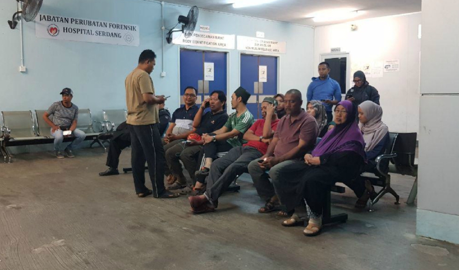 SEBAHAGIAN ahli keluarga dan rakan Muhammad Ilham Fahmy menunggu di pekarangan Jabatan Perubatan Forensik, Hospital Serdang, hari ini, bagi menunggu jenazah selesai dibedah siasat. FOTO Nurul Hidayah Bahaudin.