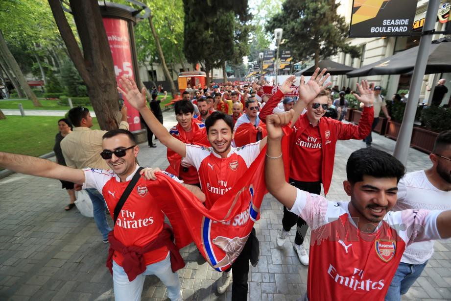 PENYOKONG Arsenal bersama bendera Gunners di pusat bandar Baku. — FOTO Reuters
