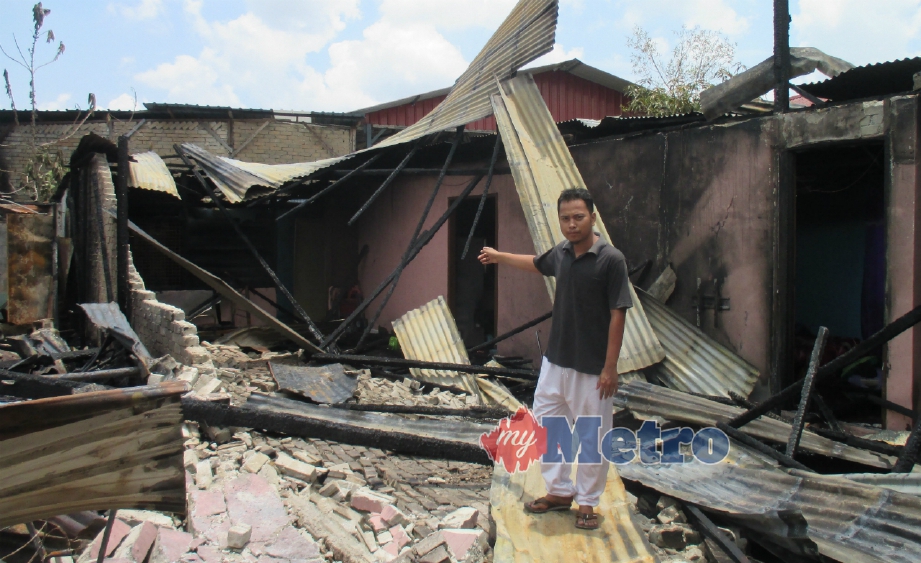 MUHAMMAD Fariq menunjukkan  rumahnya yang  musnah dijilat api dalam kebakaran di Kampung Terengganu, Teluk Intan. FOTO Abu Bakar Al Sidek