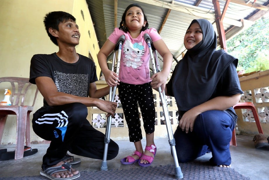 Nurain (kanan) dan Abdullah (kiri) membantu Farisha Alina yang menghadapi masalah kecacatan kaki (CTEV).NSTP/Adi sAFRI