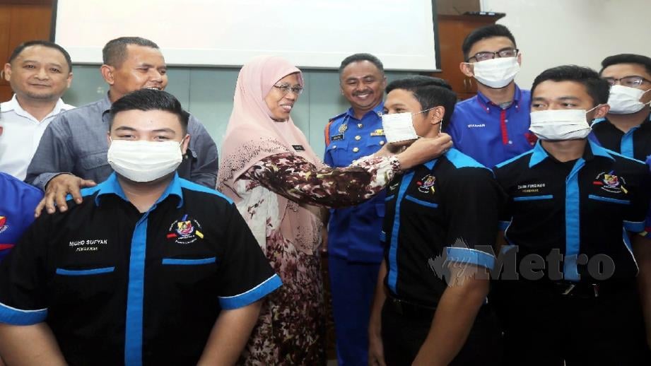 Farizah memakaikan topeng penutup hidung kepada pelajar di majlis penyerahan 40,000 penutup hidung kepada pihak sekolah sekitar Putrajaya di Sekolah Sultan Alam Shah, Putrajaya hari ini. Foto Mohd Fadli Hamzah 