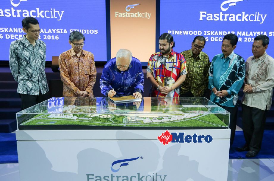 TUNKU Mahkota Johor, Tunku Ismail Sultan Ibrahim menyaksikan Perdana Menteri, Datuk Seri Najib Razak menandatangani plak ketika majlis pelancaran reka bentuk pembangunan Fastrackcity di Pinewood Studios, Iskandar Puteri. FOTO Asyraf Hamzah 