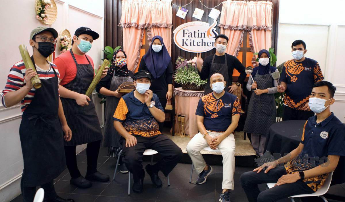 HASSAN (duduk kiri) dan Ahmad Jamil bersama sebahagian bekas kakitangan hotel yang bekerja di Fatin Kitchen’s. FOTO Mohd Yusni Ariffin