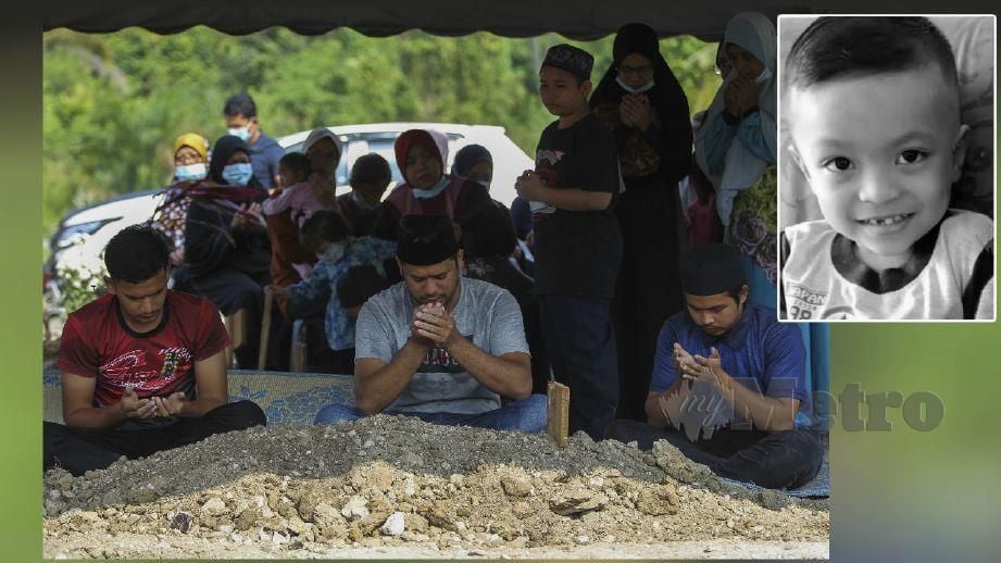 MOHD Bukhari Zainal (tengah)  membacakan doa buat anaknya Allahyarham Muhammad Fawwaz Adli di Tanah Perkuburan Islam Senawang. FOTO Azrul Edham Mohd Aminuddin