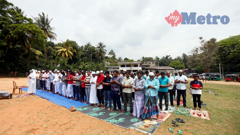 Jemaah bersolat di kawasan terbuka selepas masjid musnah berikutan perbalahan dua komuniti di Digana, Kandy, Sri Lanka. FOTO REUTERS