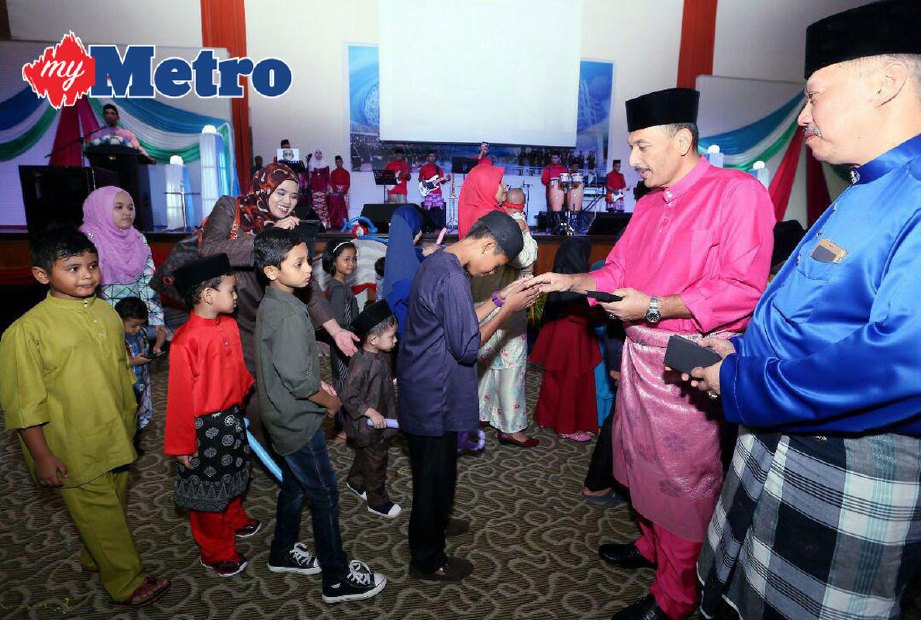 Mior Farid (dua dari kanan) menyampaikan duit raya kepada kanak-kanak pada majlis Jamuan Hari Raya Aidilfitri Jabatan Siasatan Jenayah Kedah di Ibu Pejabat Polis Kontinjen Kedah. FOTO Amran Hamid