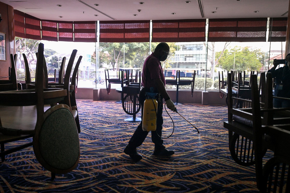 Pekerja salah sebuah hotel terkemuka di George Town melakukan kerja-kerja sanitasi di kawasan hotel selepas aktiviti pelancongan dalam negeri dibenarkan oleh kerajaan bermula esok ketika tinjauan hari ini. FOTO BERNAMA