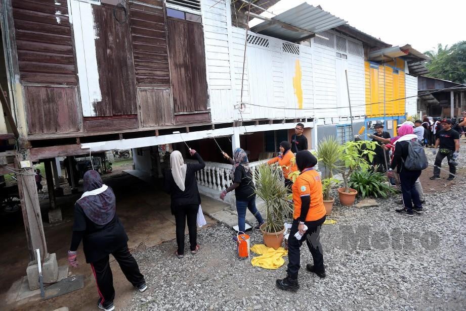 WARGA kerja PKNS bergotong-royong baik pulih Rumah Asnaf Fakir Miskin Daerah Kuala Langat di Jalan Pulai Kanchong Darat. -Foto SADDAM YUSOFF.