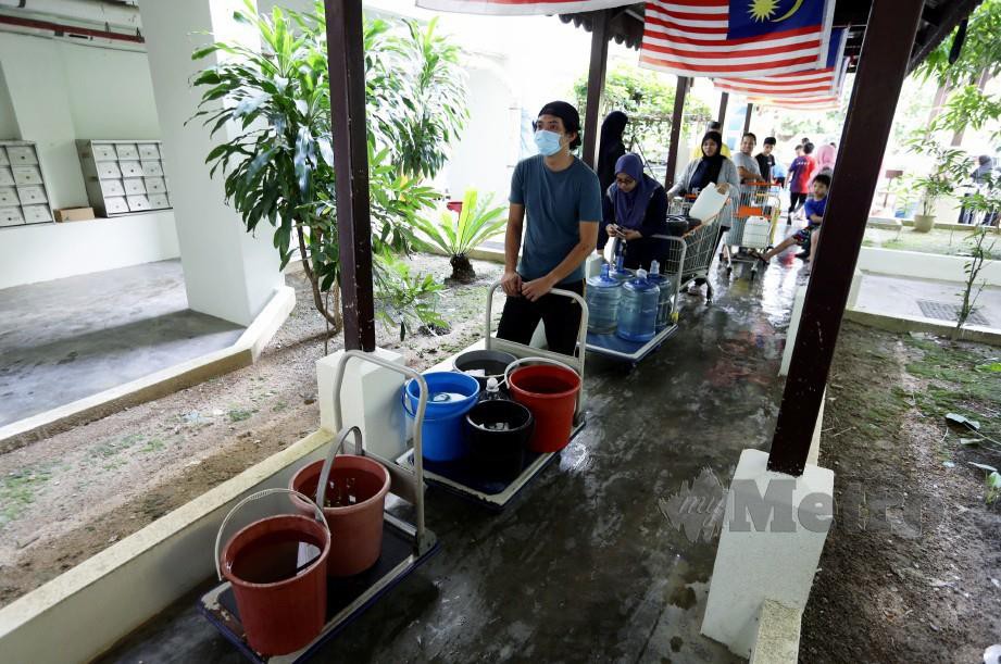 PENDUDUK Presint 16, Putrajaya mengambil air berikutan terputus bekalan air akibat pencemaran Sungai Semenyih. FOTO MOHD FADLI HAMZAH