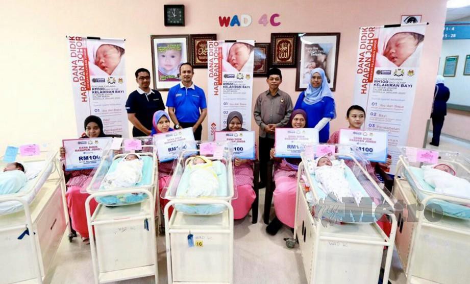 AHMAD Dasuki (dua dari kiri) bersama Zeen Watak (tiga dari kiri) dan Mastura (kanan) meraikan lima ibu dan bayi mereka yang menjadi penerima terawal insentif tabungan SSPN-i menerusi Dana Didik Harapan Johor di Hospital Sultan Ismail. FOTO IHSAN PTPTN