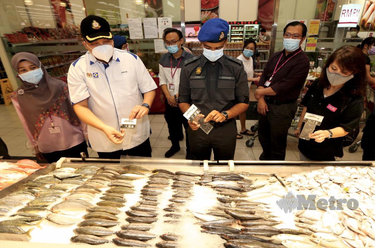 ARIFFIN (dua dari kiri) bersama anggotanya meninjau harga ikan ketika melakukan pemeriksaan barangan keperluan pengguna sempena perlaksanaan Perintah Kawalan Pergerakan (PKP) 2.0 di AEON Big Kepong, Kuala Lumpur. FOTO MOHAMAD SHAHRIL BADRI SAALI