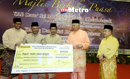  Datuk Seri Najib menerima replika cek zakat daripada Pengerusi FELDA Tan Sri Mohd Isa Samad. - Foto MOHD FADLI HAMZAH