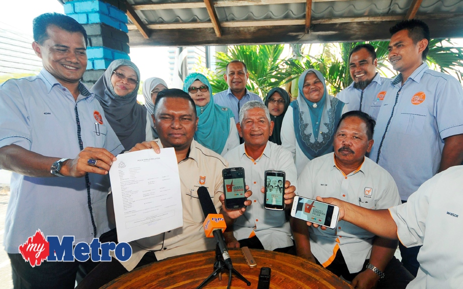 Ismail (tengah) bersama kakitangan Felda Wilayah Terengganu menunjukkan laporan polis dan gambar selepas membuat laporan polis membabitkan Pakatan Harapan. FOTO Mohd Syafiq Ridzuan Ambak 