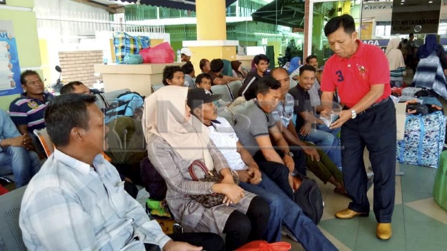 Ketua Keselamatan Terminal Kukup, Mohd Aziz Mohd Amin (kanan) menjelaskan masalah ketiadaan feri kepada penumpang. FOTO Togi Marzuki.