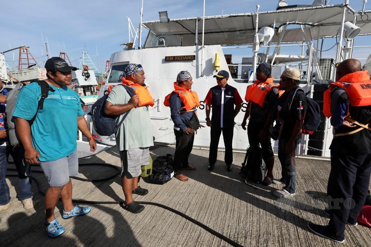 Muhammad Suffi (empat dari kanan) bertanyakan khabar 10 orang  pemancing dan tiga kru yang dikhuatiri hilang sebelum ini di laut apabila selamat  tiba di Jeti Maritim Malaysia di sini. FOTO GHAZALI KORI