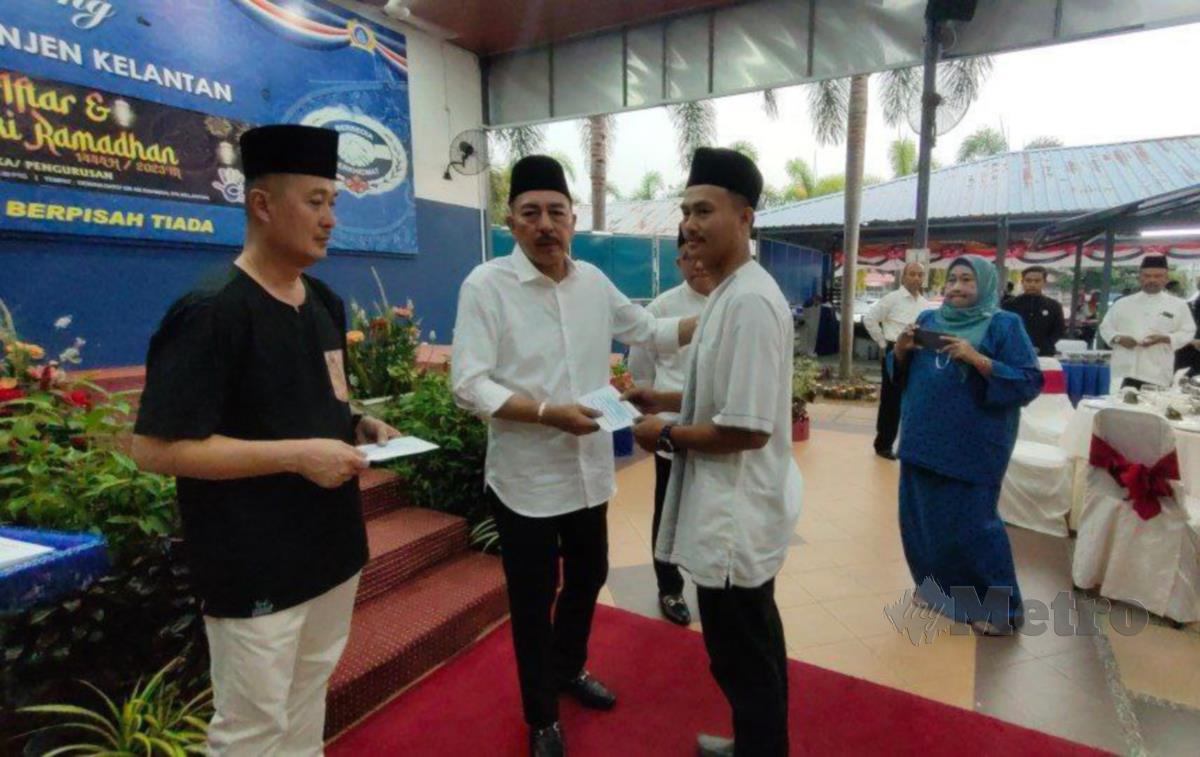 Muhamad Zaki (dua dari kiri) menyampaikan sumbangan zakat kepada salah seorang anggota mualaf di Majlis Iftar dan Kongsi Rezeki Ramadan Peringkat Kontinjen Kelantan di Ibu Pejabat Polis Kontinjen (IPK) Kelantan. FOTO SYAHERAH MUSTAFA