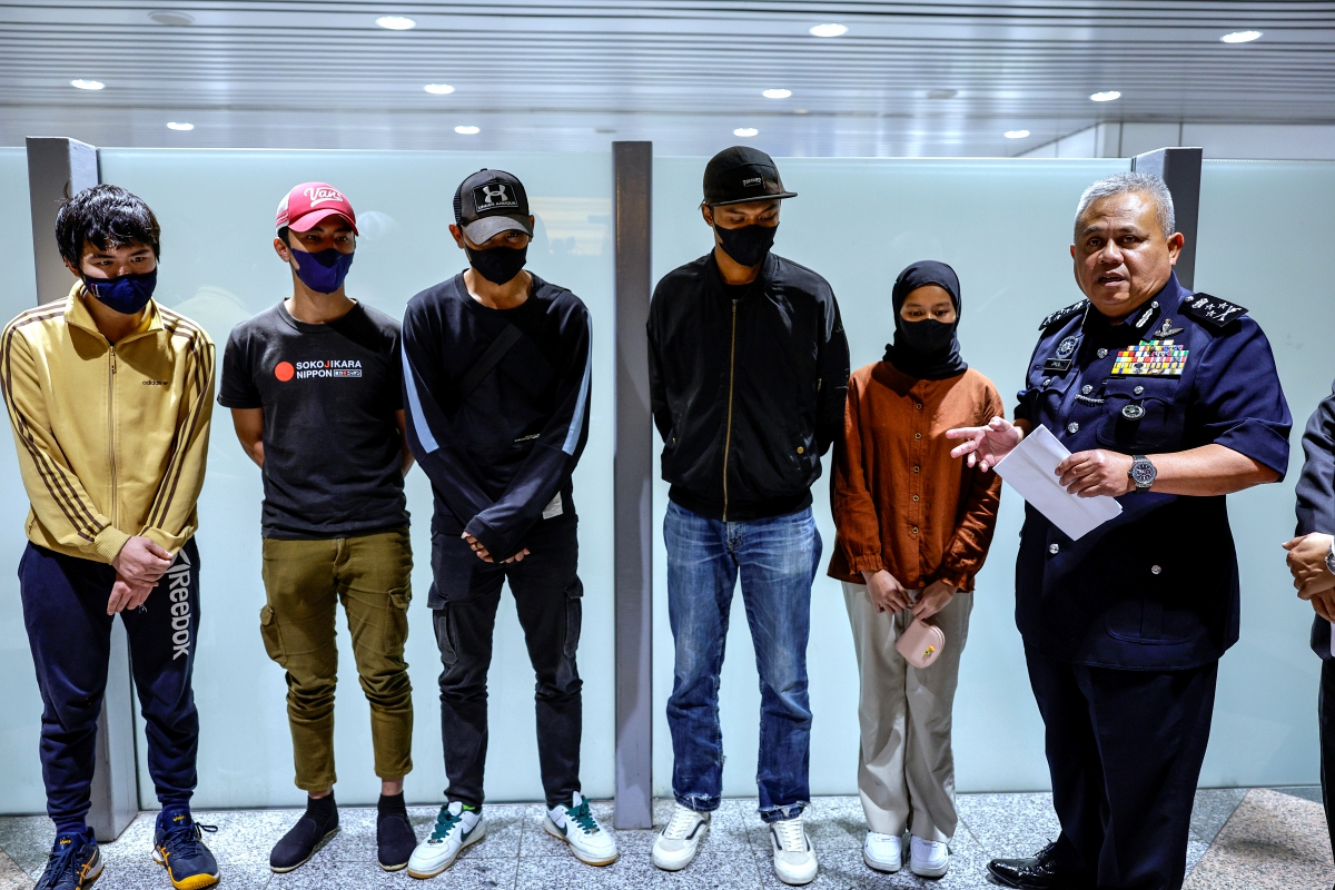 Pengarah Jabatan Siasatan Jenayah (JSJ) Bukit Aman Datuk Seri Abdul Jalil Hassan (kanan) bersama lima orang mangsa penipuan kerja di Thailand, ketika sidang media berkenaan kejayaan membawa mereka pulang di Lapangan Terbang Antarabangsa Kuala Lumpur (KLIA). FOTO BERNAMA