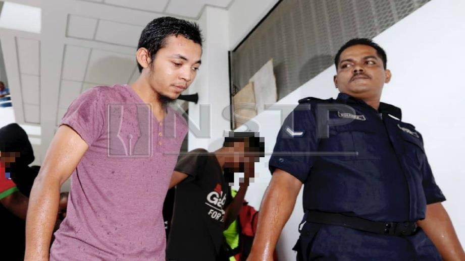MOHAMMAD Firdaus (kiri) dibawa ke Mahkamah Majistret Balik Pulau, hari ini. FOTO Mikail Ong