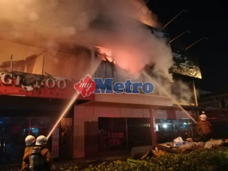 ANGGOTA bomba memadamkan kebakaran kedai berkenaan. FOTO Ihsan Bomba 