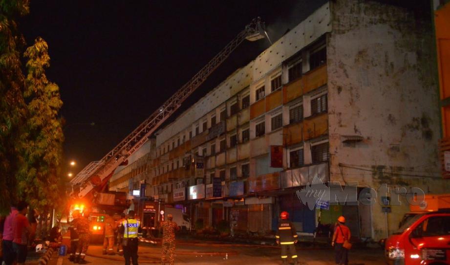 ANGGOTA bomba berusaha memadam kebakaran bangunan rumah kedai tiga tingkat di Jalan Nenas, Klang, malam ini. FOTO Faiz Anuar. 