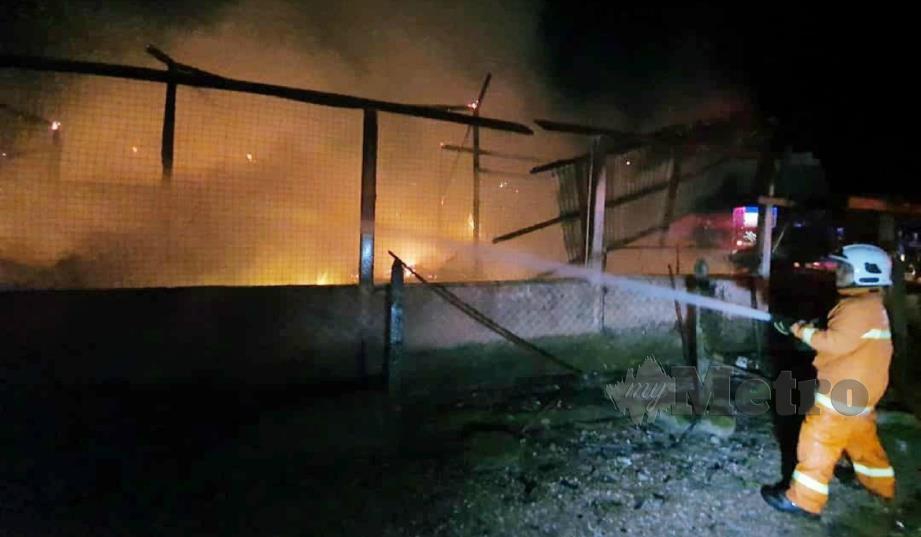 ANGGOTA bomba berusaha memadam kebakaran sebuah rumah peneroka di Felda Kerteh Satu, Dungun, malam tadi. FOTO Rosli Ilham. 