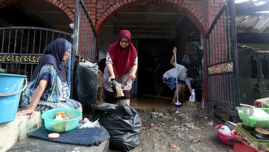 PENDUDUK membersihkan rumah mereka yang kotor akibat ditenggelami air dalam kejadian banjir kilat di Taman Muhibbah, Sungai Chua, Kajang. FOTO Hairul Anuar Rahim
