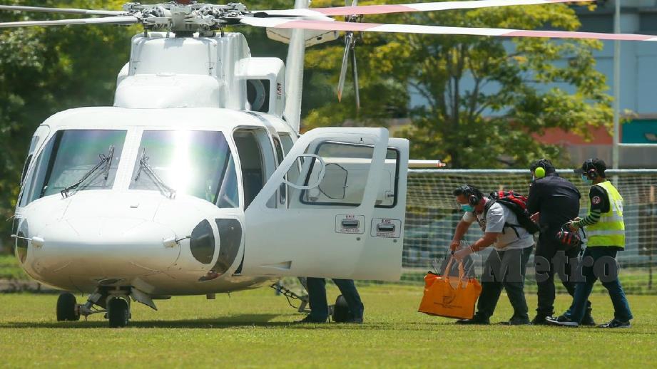 DATUK Abdul Ghani Salleh (tengah) menyerahkan peti undi kepada petugas SPR untuk dihantar ke pusat undian pedalaman dan kepulauan dengan menaiki helikopter sewa khas di Pusat Kebudayaan Sabah, Penampang. FOTO ASWADI ALIAS.