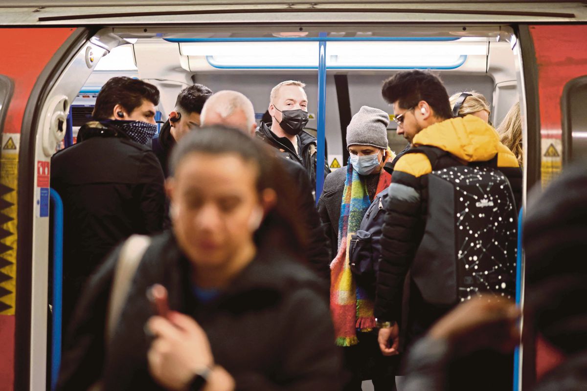 ADA pengguna pengangkutan awam di London dilihat masih memakai pelitup muka meskipun pihak berkuasa sudah menarik balik peraturan pemakaian pelitup muka di England. FOTO AFP 