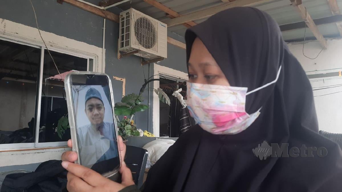 Nurul Diyana Mohd Shukri menunjukkan gambar Allahyarham suami, Muhammad Izzat Abdul Wahab ketika ditemui di Kampung Peramu, Kuantan. FOTO Asrol Awang