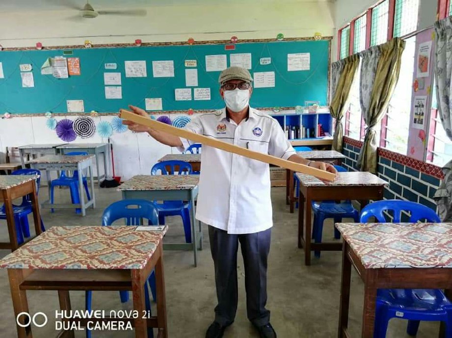 MD Yusof menunjukkan penjarakan antara meja dalam kelas.