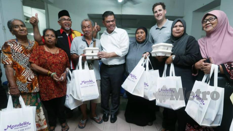 Saifuddin Nasution (lima dari kanan) bersama antara penerima sumbangan makanan pada majlis penyampaian makanan kepada penduduk PPR Desa Tun Razak. FOTO Rohanis Shukri