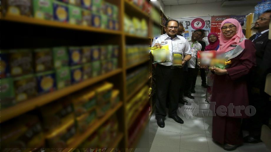 HASNOL (kiri) menunjukkan antara barangan yang berada di Pantri Food Bank Siswa di Politeknik Port Dickson. FOTO Mohd Khidir Zakaria. 