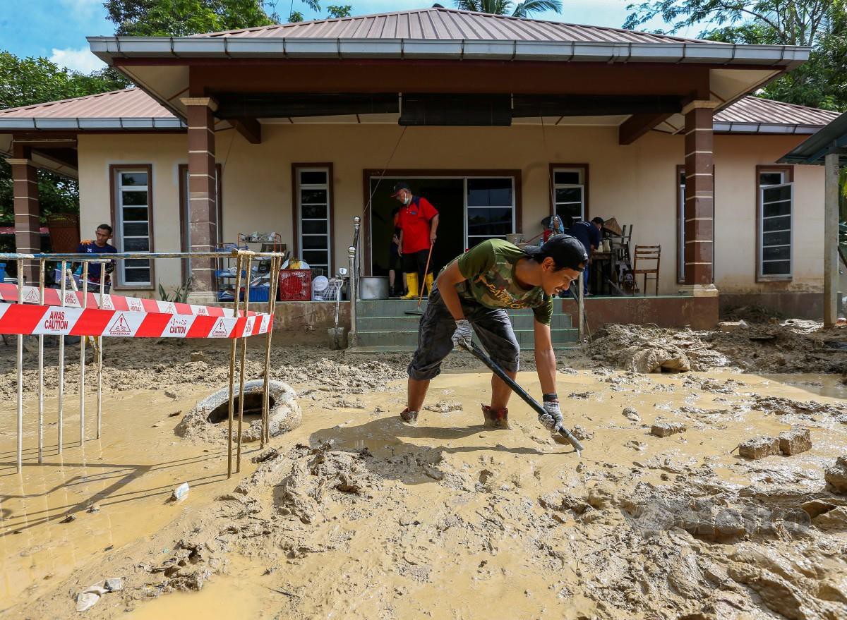 PENDUDUK mengemas dan membersih kawasan rumah selepas banjir surut. FOTO Azrul Edham Mohd Aminuddin