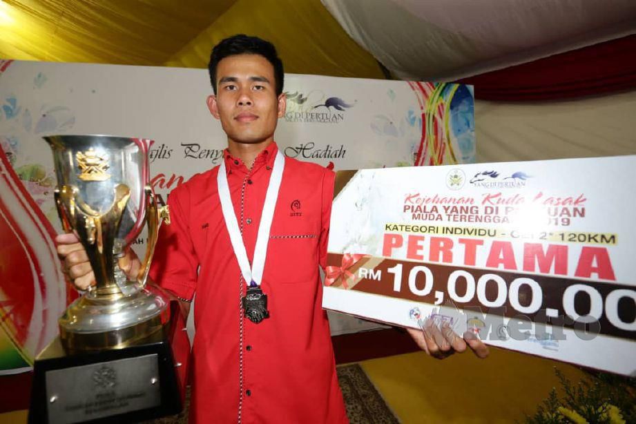 FUAD bersama hadiah wang tunai dan trofi dimenanginya pada Kejohanan Kuda Lasak Piala Yang di-Pertuan Muda Terengganu di Lembah Bidong. — FOTO Rozainah Zakaria