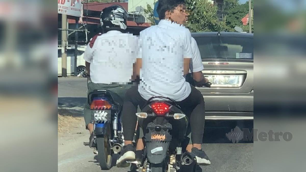 DUA pelajar membonceng motosikal dengan baju diconteng perkataan mencarut dan menghina guru. FOTO ihsan pembaca 