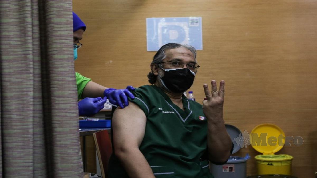 Pakar Bedah Telinga KPJ Tawakkal Kuala Lumpur, Datuk Dr Solahuddin Mohd Kenali menunjukkan isyarat tiga jari selepas menerima suntikan dos penggalak bulan lalu. HAZREEN MOHAMAD