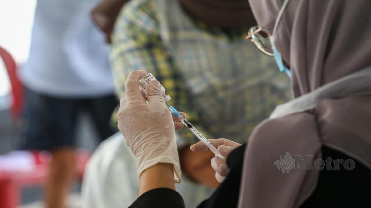 SUKARELAWAN Malaysian Medical Relief Society (MERCY) menyediakan picagari sebelum memberi suntikan dos penggalak kepada warga emas ketika tinjauan di Berangin Park Nursing Care, Batu Berendam, Melaka. FOTO SYAFEEQ AHMAD