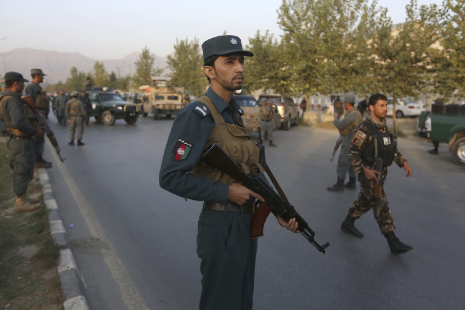 Anggota keselamatan Afghanistan berkawal di depan American University of Afghanistan di Kabul selepas serangan berakhir. - Foto AP